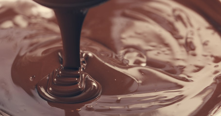 premium dark melted chocolate being poured from spoon closeup toned, 4k photo