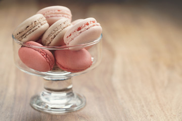macarons with strawberry, rose and caramel flavour in glass bowl, shallow focus