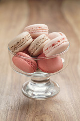 macarons with strawberry, rose and caramel flavour in glass bowl, shallow focus