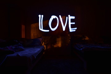 sypialnia nocą z napisem love © Pawe