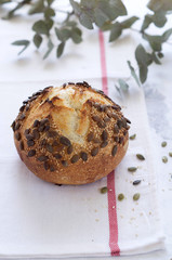 Loaf of bread on whole wheat sourdough with sesame seeds and sunflower seeds. On a white background