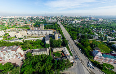 Aerial city view with crossroads and roads, houses, buildings, parks and parking lots, bridges. Copter shot. Panoramic image.