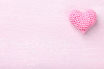 Crochet pink heart on pink wooden background