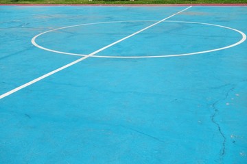 White line on colorful concrete floor of outdoor basketball court.