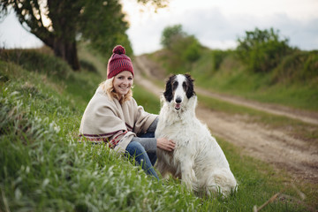 Woman and her dog resting outdoor.