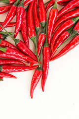 red hot chili peppers, popular spices concept - beautiful handful of plenty red hot pepper in bulk, pods scattered on white background, top view, flat lay, vertical with free space for your text