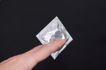 Guy holding a condom