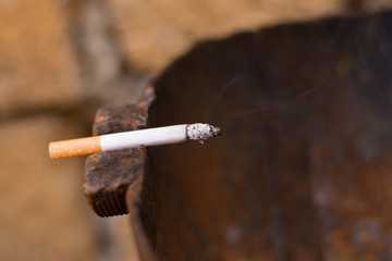 Burning cigarette on a cut gas bottle