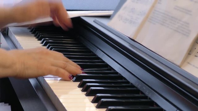 Pianist enjoys playing the piano. Hands of a woman playing music on a keyboard instrument. Fingers on the keys.