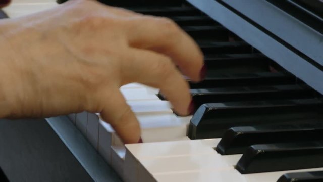 Pianist plays the piano furiously. Hands of a woman playing music on a keyboard instrument. Fingers on the keys.