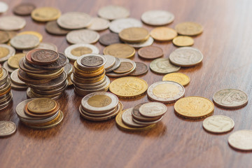 Different gold and silver collector's coins on the wooden table