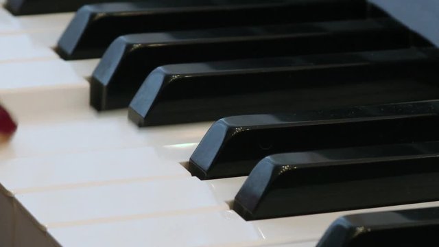 Pianist enjoys playing the piano close up. Hands of a woman playing music on a keyboard instrument. Fingers on the keys.
