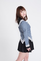 若い女性が制服を着ています。手の表情が豊かです。サイネージや広告宣伝に適した画像です。この画像の背景は、白です。