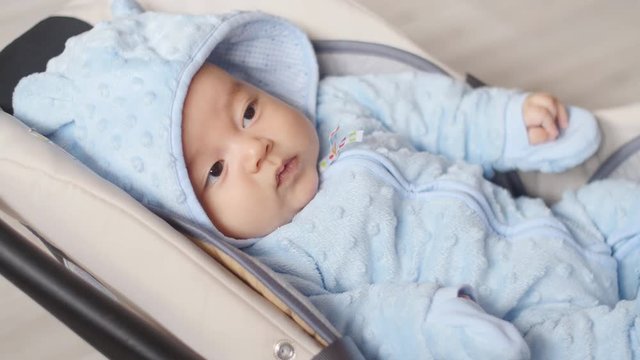 Newborn baby boy sitting in a car seat