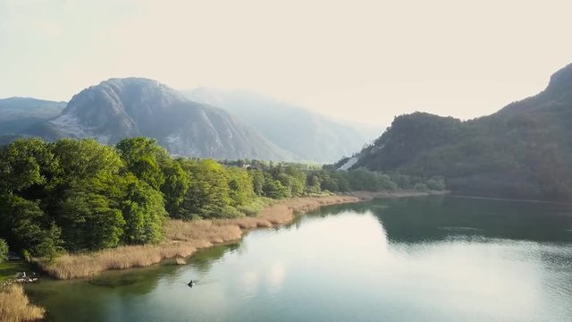 Drohnen Flug &uuml;ber Bergsee am Fusse der Alpen an der grenze zur Schweiz