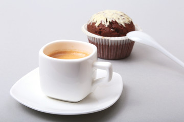 Classic espresso in white cup with homemade cake and chocolate on white background.
