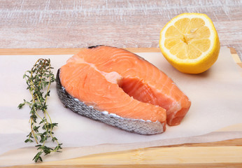 fresh raw salmon with spices and lemon on wooden cutting board. ready for cookin