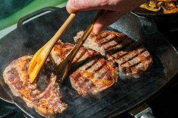 Raw Ribeye Steak with Herbs and Spices, frying on grill pan