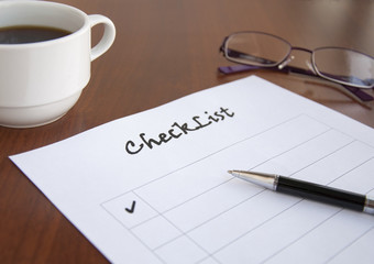 blank checklist on wooden table With coffee and glasses