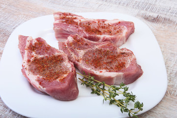Raw pork chops, spices and rosemary on cutting board. Ready for cooking.