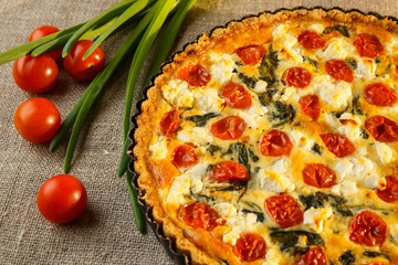 Vegetarian homemade pie, Quiche with tomatoes, spinach and feta cheese.