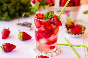 Homemade strawberry lemonade with mint on a white background