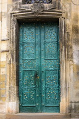 Fototapeta na wymiar retro green wooden door on a cracked concrete vintage wall background 