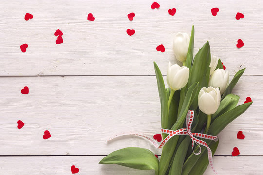 Background with white tulips and  hearts on white boards. Place for text.