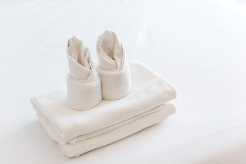 folded white towel in a hotel bedroom