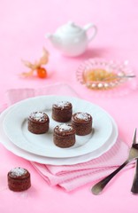 Chocolate Coconut Mini Cupcakes on white plate, on light pink background.