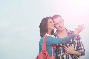 Happy girl and handsome man taking selfie together