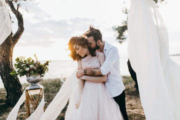 Elegant bride and groom at the evening ceremony near the ocean