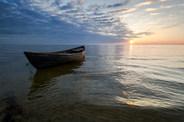 Lonely boat on the sea at sunset.