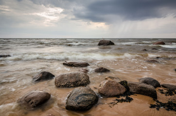Seascape. Storm clouds gathering over the rocky beach.