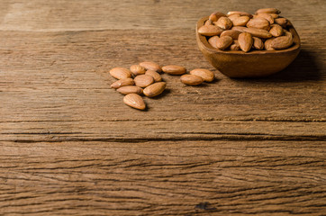 almond from wooden bowl on wooden board