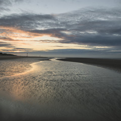 Stunning colorful Winter sunrise over low tide beach