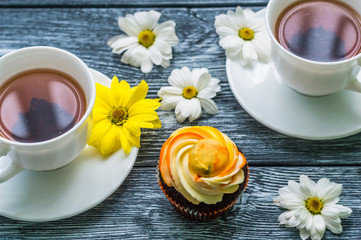 Still life with cup of tea and cake on the wooden background