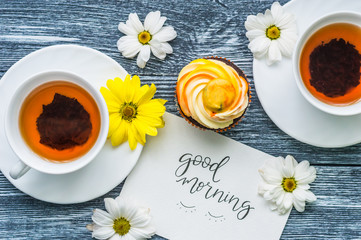 Still life with cup of tea and cake on the wooden background