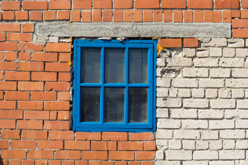 small blue window in a brick wall