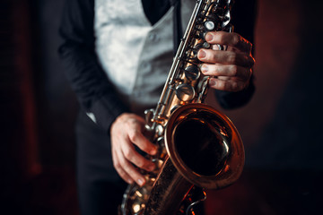 Jazz man hands holding saxophone closeup - obrazy, fototapety, plakaty