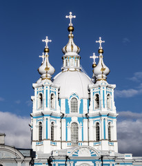 Fototapeta na wymiar Russia,Saint Petersburg. Smolny Cathedral (Church of the Resurrection). Cathedral facade. Clear blue sky and golden crosses.
