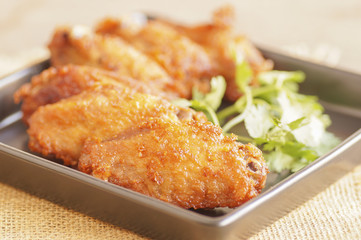 Close up Spicy Deep Fried Breaded Chicken Wings with Ranch and coriander on black plate