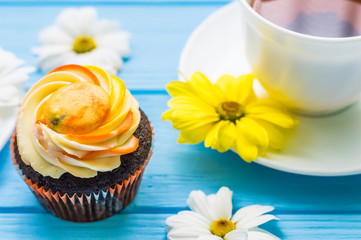 Still life with cup of tea and cake on the wooden background