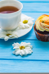 Still life with cup of tea and cake on the wooden background