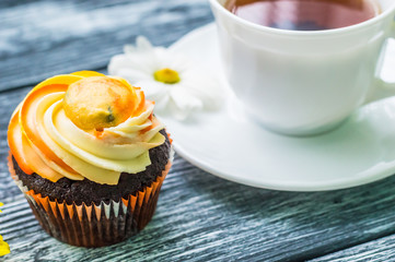 Still life with cup of tea and cake on the wooden background