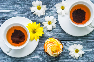 Still life with cup of tea and cake on the wooden background