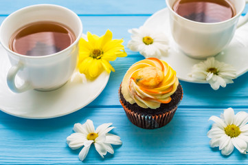 Still life with cup of tea and cake on the wooden background