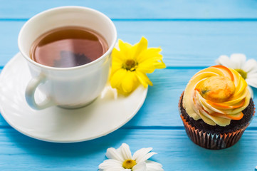 Still life with cup of tea and cake on the wooden background