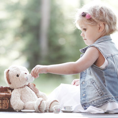 Girl playing with teddy bear