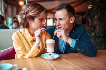 Couple drink a cocktail together from the straws